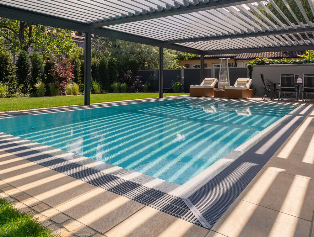 Pool mit eigenem Sonnen- und Regenschutz im Garten. Aufenthalts Bereich mit Liegen und Tisch.